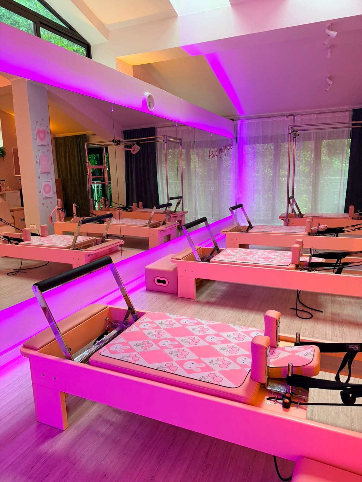 Aparate Reformer roz în studioul LUNEA Pilates, cu lumină ambientală caldă